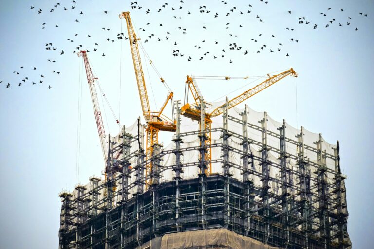 low angle photography of cranes on top of building