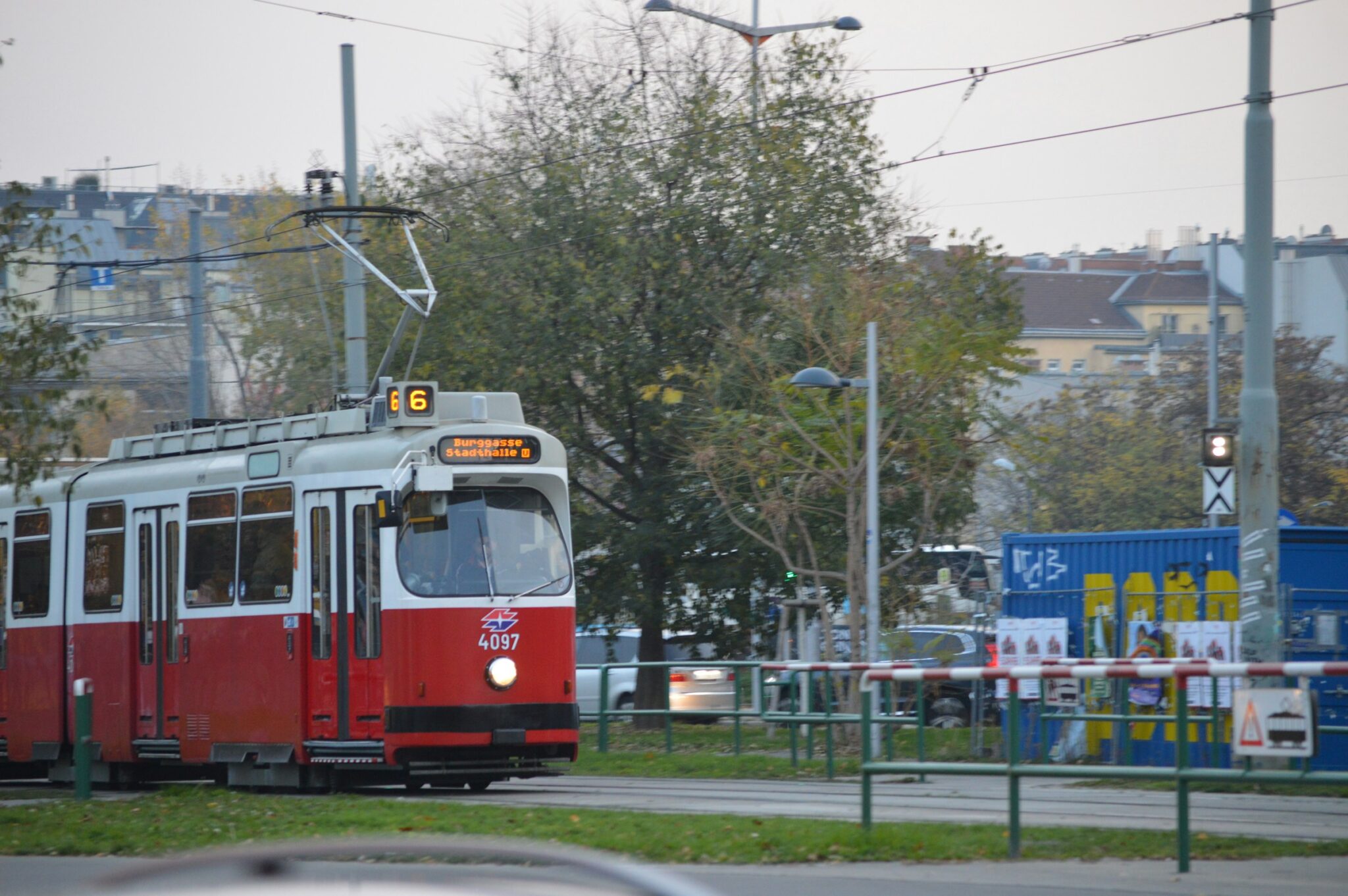 A red and white trolley traveling down a street